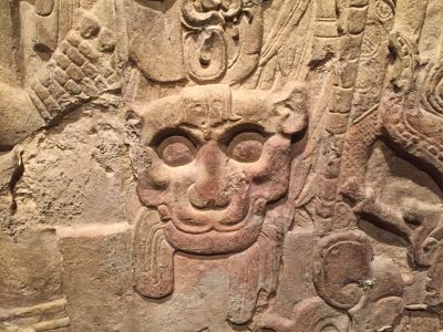 Stone art of the 8th Century Guatemala (image courtesy of Metropolitan Museum of Art). It appears to be the face of a dragon surrounded by uneven, geometric patterns.